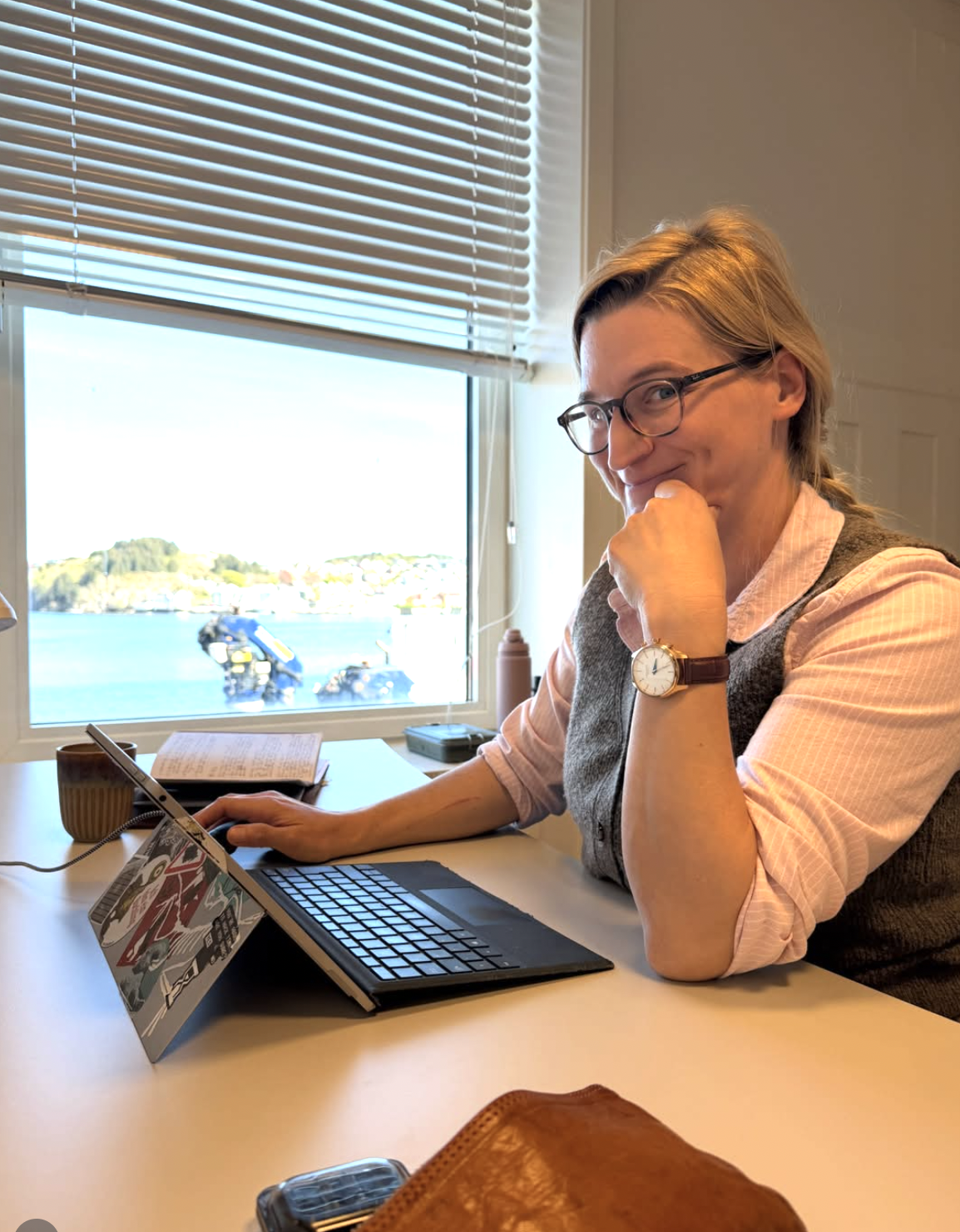 Medlem ved pult med utsikt mot havna